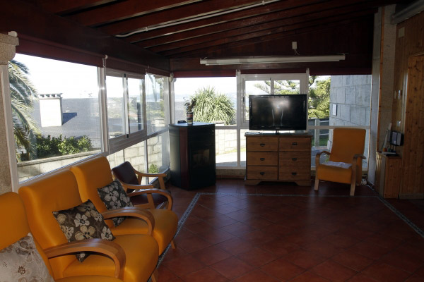 Centro Residencial Coruxo sala con sillas y televisor